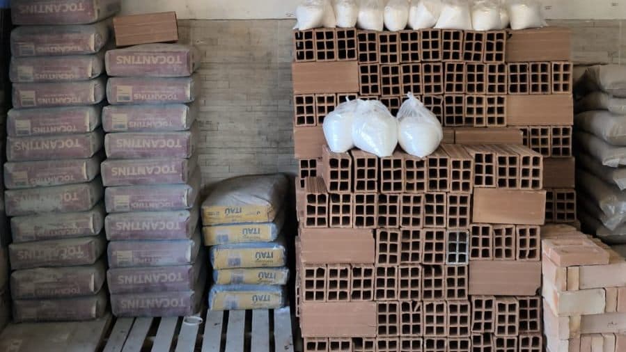 Sacos de cimento empilhados ao lado de tijolos e argamassas no depósito da Progresso Materiais de Construção em Aparecida de Goiânia