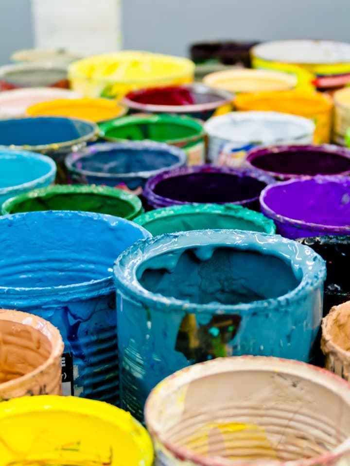 Latas de tinta abertas em várias cores, como as vendidas na loja de tintas Progresso em Aparecida de Goiânia